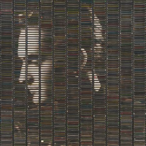 Seitenansicht eines Gesichts, dargestellt durch Hunderte von bunten Audiokassetten in Regalen angeordnet.