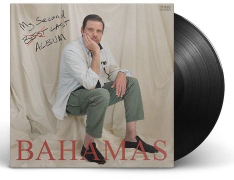 "My Second Best Album", BAHAMAS. Person sitzt nachdenklich vor hellem Hintergrund, schwarze Platte daneben.