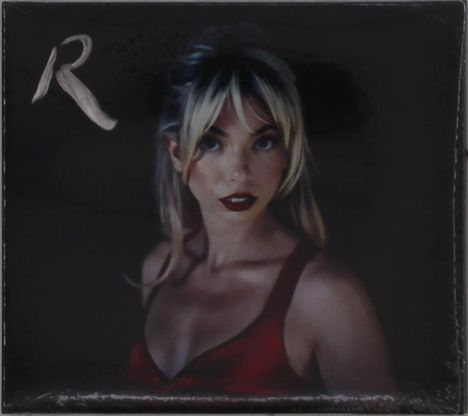 Der Text "R" in der linken oberen Ecke. Eine Frau mit blonden Haaren und rotem Top auf dunklem Hintergrund.
