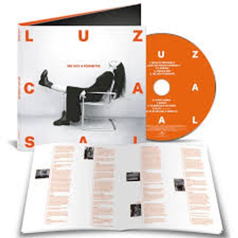 "Die Texte auf der CD und dem Cover bilden das Wort 'LUZ CASAL'. Eine Person lehnt entspannt auf einem Stuhl. Ein Booklet liegt offen."
