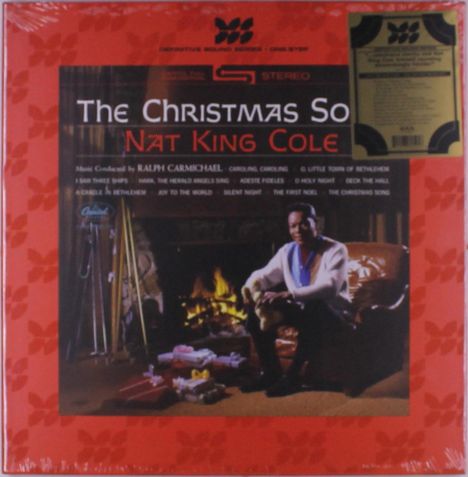 "The Christmas Song" von Nat King Cole. Rot-künstlerischer Rahmen, ein Mann am Kamin, Geschenke liegen herum.