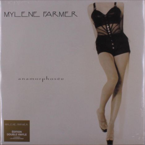 Text: "MYLENE FARMER", "anamorphosée", "ÉDITION DOUBLE VINYLE". Frau in schwarzem Outfit steht elegant, Beine gekreuzt.
