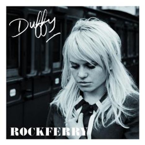 Text: "Duffy - Rockferry". Eine blonde Frau steht nachdenklich vor einem Zug. Schwarz-Weiß-Bild.