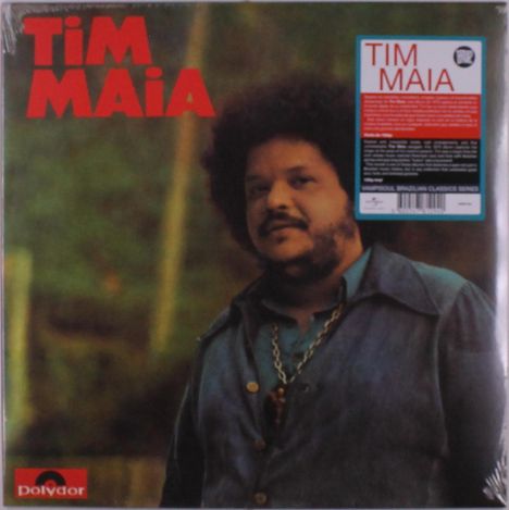 "TIm MAIA" in roten Buchstaben oben links. Ein Mann mit lockigem Haar und Bart trägt eine Kette, vor einem verschwommenen Hintergrund. 