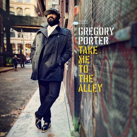 "GREGORY PORTER, TAKE ME TO THE ALLEY" steht neben einem Mann in Mantel und Hut, der in einer Gasse lehnt.