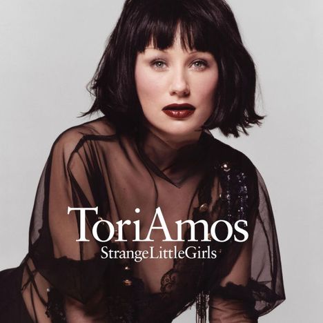 Tori Amos, StrangeLittleGirls. Frau mit schwarzem Haar und rotem Lippenstift in transparentem, schwarzem Outfit.
