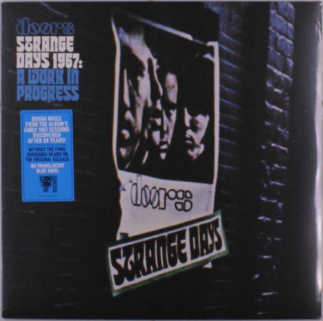 „Strange Days 1967: A Work in Progress“ in großer Schrift. Ein Vintage-Poster klebt an einer Backsteinmauer.