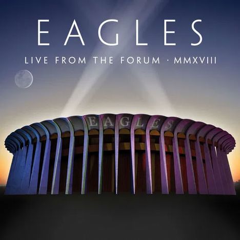 "EAGLES LIVE FROM THE FORUM MMXVIII" über einem beleuchteten runden Gebäude bei Abenddämmerung.