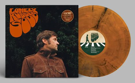 Links der Text: "Lonely Rubber Soul". Rechts eine gelbe Schallplatte. Ein Mann in brauner Jacke blickt zur Seite.