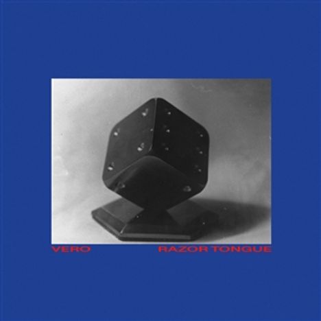 Text: "VERO RAZOR TONGUE". Schwarz-Weiß-Foto eines Würfels auf einem Sockel, blauer Hintergrund.