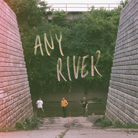 Text: "ANY RIVER". Drei Personen stehen zwischen großen, steinernen Mauern. Im Hintergrund dichter Wald und ein Fluss.