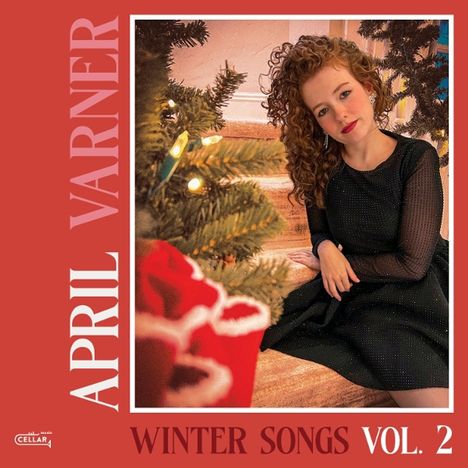 "APRIL VARNER" und "WINTER SONGS VOL. 2". Eine Person in festlicher Umgebung neben einem Weihnachtsbaum.