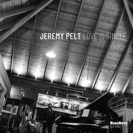 JEREMY PELT LOVE IS SIMPLE. Schwarz-Weiß-Szene in einem Raum mit Holzdach, Kontrabass und Klavier.