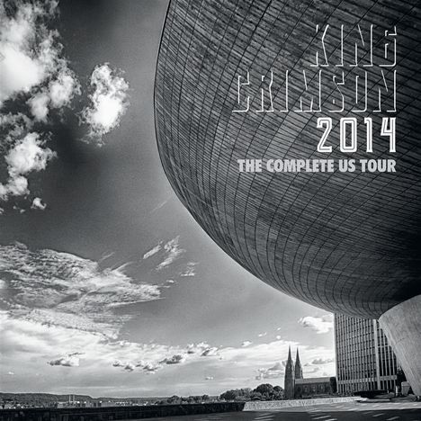 „KING CRIMSON 2014 THE COMPLETE US TOUR“ über einer futuristischen Gebäudekuppel, daneben Wolken und Landschaft.