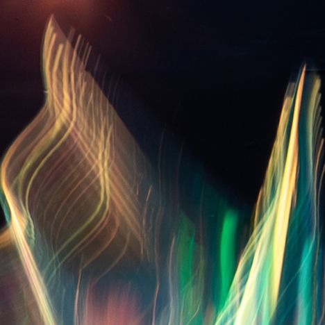 Leuchtende, wellenartige Linien in verschiedenen Farben auf dunklem Hintergrund, erzeugen ein abstraktes und fließendes Muster.