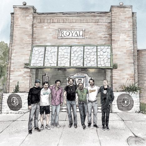 Text "ROYAL" über einem Gebäudeeingang. Eine Gruppe von sieben Menschen steht davor auf dem Gehweg.