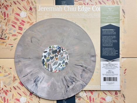 Jeremiah Chiu Edge Com. Eine Schallplatte mit abstraktem, buntem Design auf einem gemusterten Hintergrund.