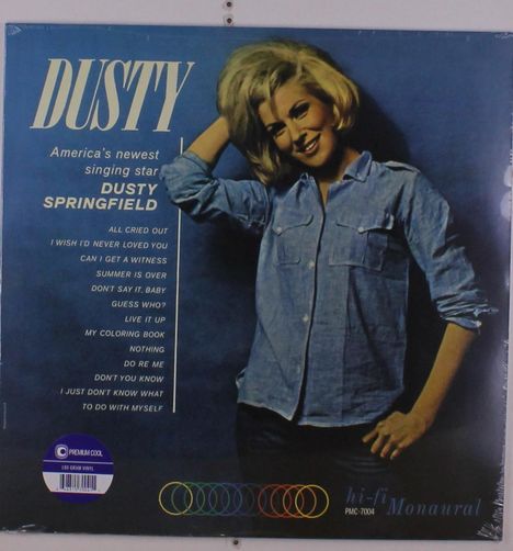 Text: "DUSTY", "America's newest singing star", "DUSTY SPRINGFIELD", Songtitel. Frau in blauem Hemd, lächelnd.