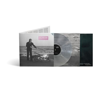 KALI MALONE BURNING SONG. Eine Person steht am Strand neben einem Feuer. Schallplatte im transparenten Vinyl.