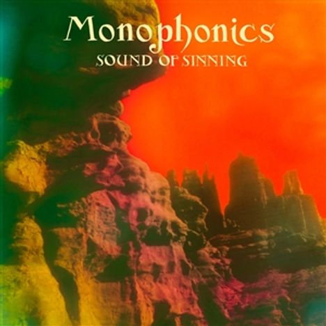 "Monophonics SOUND OF SINNING" ist in einem farbenfrohen Himmel über einer Landschaft aus bizarren Felsformationen.