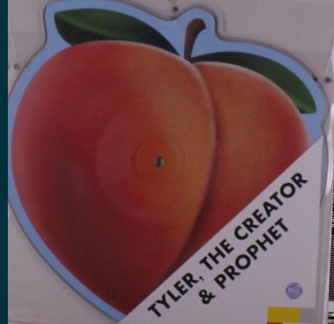 „TYLER, THE CREATOR & PROPHET.“ Illustration einer großen, saftigen Pfirsichfrucht mit Blatt.