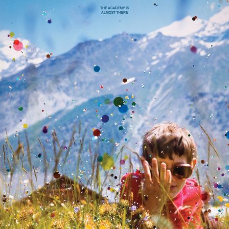 "The Academy Is Almost There." Kind mit Sonnenbrille in einer bunten Wiese, im Hintergrund schneebedeckte Berge.