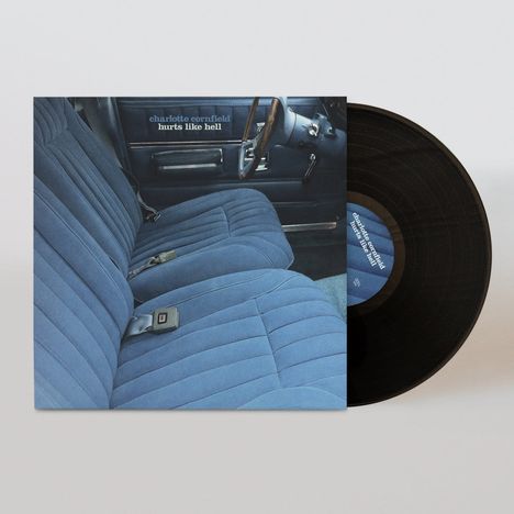 Text: "charlotte cornfield hurts like hell". Vinylhülle zeigt blaue Autositzbank. Eine Schallplatte ist teilweise sichtbar.