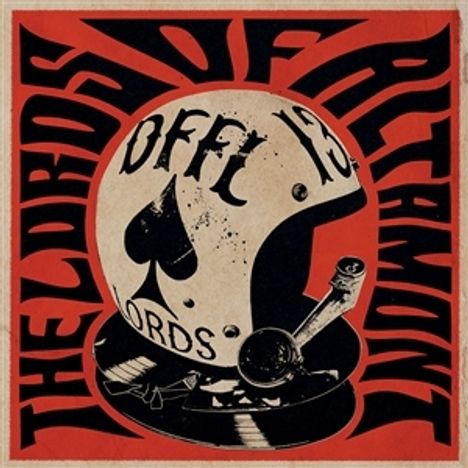 "The Lords of Altamont" umrahmt einen Helm mit Kreuz und Spielkartenmotiv im Vintage-Stil.