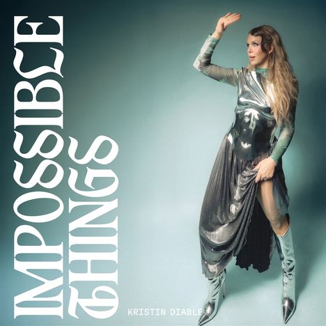Text: "IMPOSSIBLE THINGS" und "KRISTIN DIABLE". Eine Person in schimmerndem, futuristischem Outfit, posiert mit erhobenem Arm.