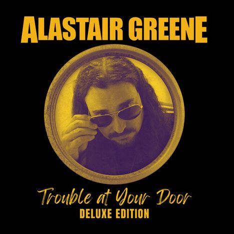 ALASTAIR GREENE. Trouble at Your Door. DELUXE EDITION. Mann mit Sonnenbrille in einem runden Rahmen.