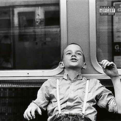 "Parental Advisory: Explicit Content" oben rechts. Schwarz-weiß Foto eines lachenden Jungen in der U-Bahn.