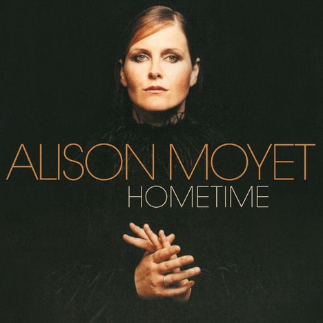 „ALISON MOYET HOMETIME“ in Großbuchstaben. Eine Frau sieht direkt nach vorne, die Hände sind gefaltet.