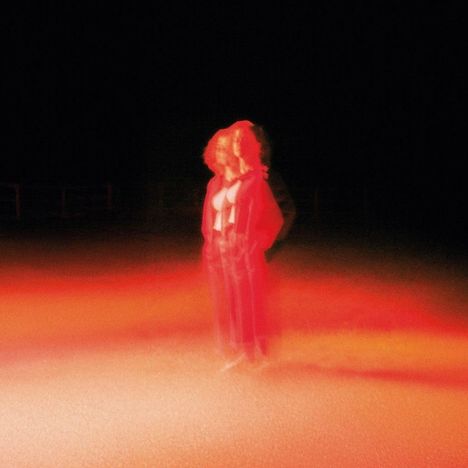 Kein Text vorhanden. Verschwommene, rot beleuchtete Person in der Dunkelheit, mit Halluzinationseffekt.