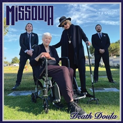Text oben links: "MISSOULA". Unten rechts: "Death Doula". Vier Personen stehen, eine sitzt im Rollstuhl im Freien.
