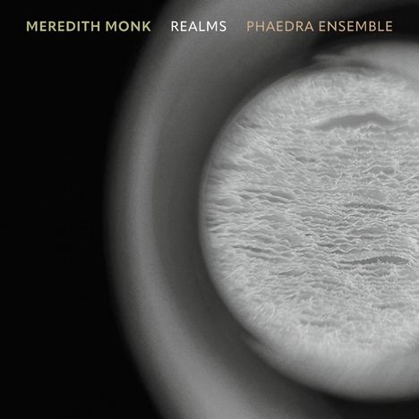 Die Texte "MEREDITH MONK," "REALMS," "PHAEDRA ENSEMBLE" sind oben. Eine abstrakte Nahaufnahme-Kreismuster in Grau.