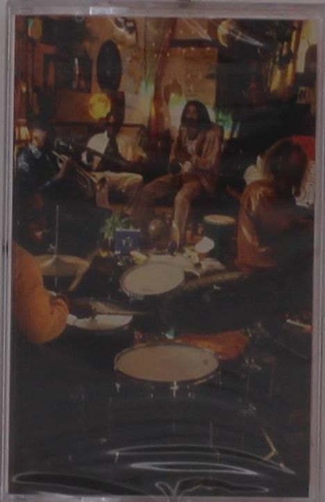 Ich kann die Texte in diesem Bild nicht lesen. Es zeigt eine Gruppe von Musikern, die in einem gemütlichen Raum spielen.