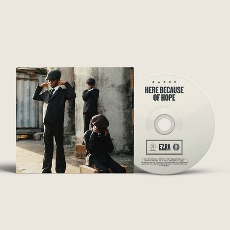 Auf der CD steht "HERE BECAUSE OF HOPE". Links drei Kinder in Anzügen, zwei stehen, eins sitzt.