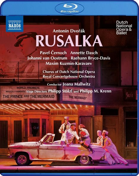 "Antonín Dvořák: RUSALKA" ist prominent zu lesen. Auf einer Bühne tanzen Menschen in Matrosenuniformen um ein Auto.