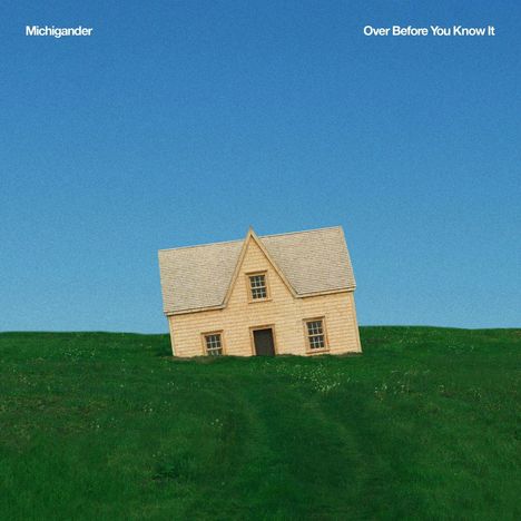 Texte: "Michigander" und "Over Before You Know It". Ein Haus in Schräglage auf grünem Hügel bei klarem Himmel.