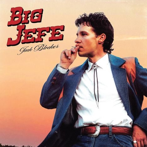 Text: "BIG JEFE", "Jack Blocker". Ein Mann in Cowboy-Kleidung raucht und blickt nach rechts, vor einem orangefarbenen Himmel.