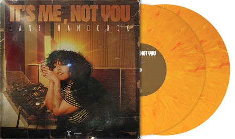 "IT'S ME, NOT YOU," "JANE HANDCOCK" steht in großen Buchstaben. Eine Frau mit Locken sitzt vor Tontechnik. Gelbe Vinyl-Platten.