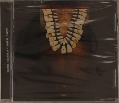 "Henry Franklin - Tribal Dance." Zu sehen ist eine Halskette aus weißen Zähnen auf dunklem Hintergrund.