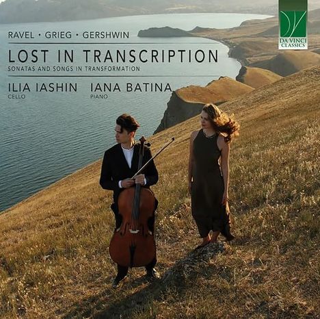 „Ravel · Grieg · Gershwin, LOST IN TRANSCRIPTION, Ilia Iashin (Cello) und Iana Batina (Piano)“. Zwei Personen auf einem Hügel mit einem Cello, im Hintergrund eine weitläufige Landschaft mit Wasser.