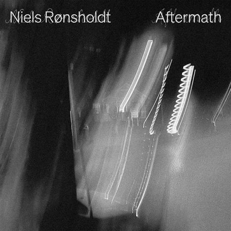 „Niels Rønsholdt Aftermath“ steht oben auf einem schwarz-weißen Bild mit verschwommenen Lichtstreifen.