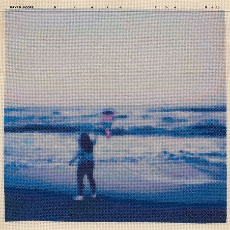 „DAVID MOORE Graze the Bell“, verschwommenes Foto eines Kindes am Strand mit einem Drachen in der Hand.