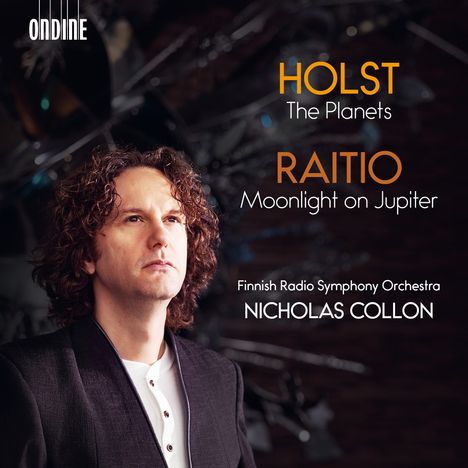 Texte: Holst The Planets, Raitio Moonlight on Jupiter, Finnish Radio Symphony Orchestra, Nicholas Collon, ONDINE. 

Mittelgrund: Ein Mann mit lockigem Haar in formeller Kleidung.