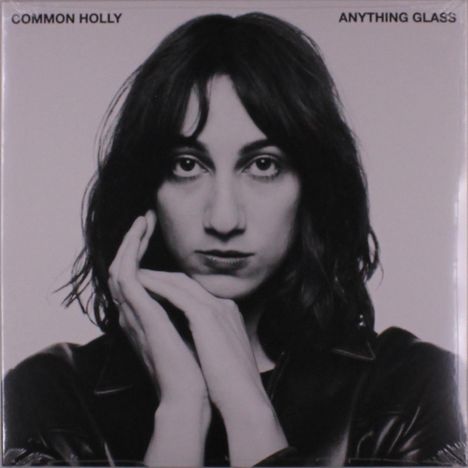 Text oben: "COMMON HOLLY ANYTHING GLASS". Schwarz-weißes Porträt einer nachdenklichen Person mit dunklem Haar.