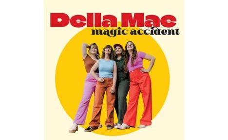 Text: "Della Mae magic accident". Vier Frauen in bunter Kleidung stehen fröhlich vor einem gelben Kreis.