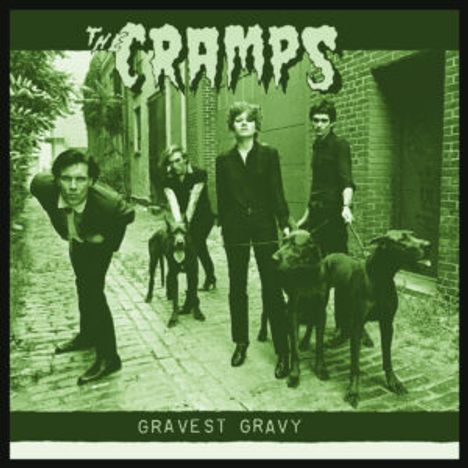 "The Cramps" und "Gravest Gravy". Vier Personen mit Hunden in einer grünen, schmalen Gasse.