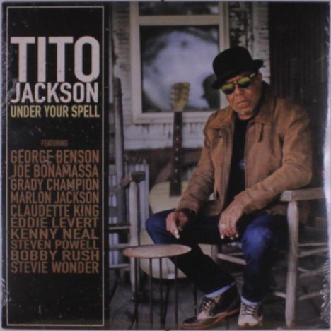 Text: "TITO JACKSON, UNDER YOUR SPELL, Featuring George Benson, Joe Bonamassa, Grady Champion, Marlon Jackson..."

Mann mit Hut und Jacke sitzt auf Veranda vor Gitarre.